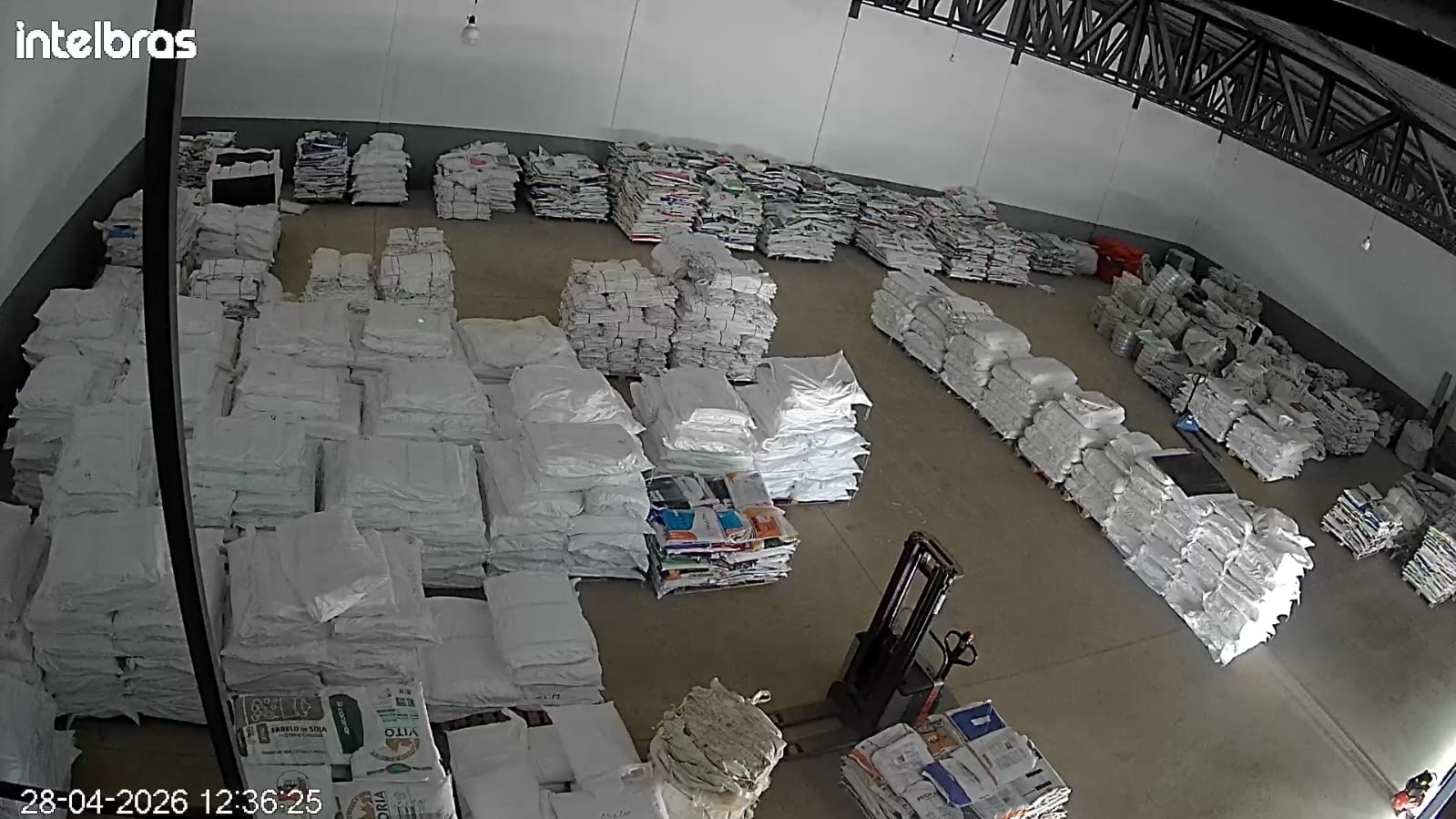 Vista ampla do galpão da Sacaria Oeste com fardos de sacarias organizados